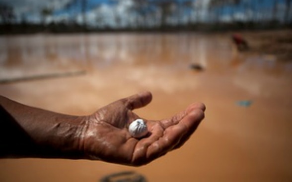 Un cercatore d’oro con del mercurio in mano.