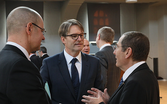 Benno Bättig, FDFA secretary-general and chairman-designate of the IHRA (centre), speaking with Israel's ambassador to Switzerland, Jacob Keidar (right), and François Wisard, head of the FDFA History Unit.
