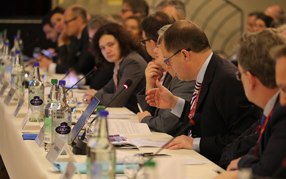 An der Plenarversammlung der IHRA in Bern diskutieren die Delegierten an einem Tisch.