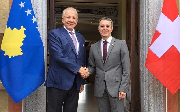 Federal Councillor Ignazio Cassis and Kosovo's Foreign Minister Behgjet Pacolli are sitting and talking at a small table.