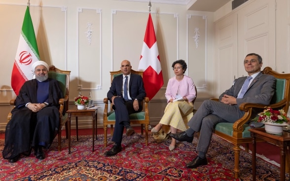 Da sinistra a destra. Il Presidente iraniano Rohani, il Presidente della Confederazione Berset e il Consigliere federale Ignazio Cassis siedono durante la riunione ufficiale. Sullo sfondo, le bandiere della Svizzera e dell'Iran.