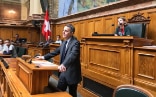 Le Conseiller fédéral Cassis prononce un discours à la tribune de la salle du Conseil national, devant les jeunes.