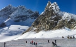 On the Aletsch glacier, people put the postcard together. In the background you can see the Jungfraujoch. 