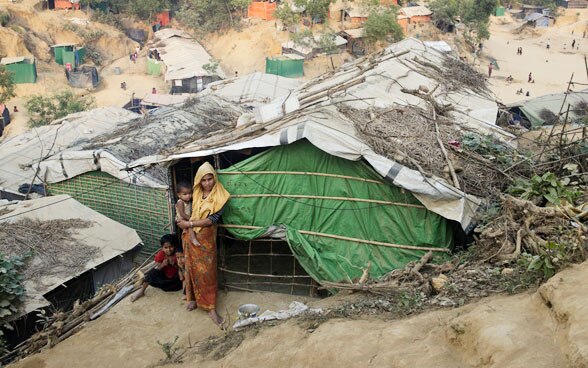 Une femme et son enfant se tiennent devant une cabane improvisée dans le camp de réfugiés Cox’s Bazar, au Bangladesh.