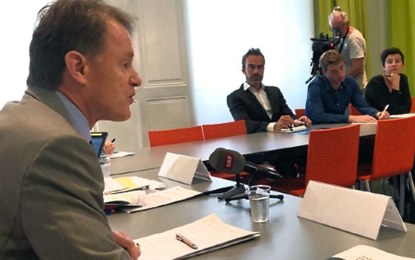 DEZA-Direktor Manuel Sager diskutiert mit Journalisten an einem Tisch.
