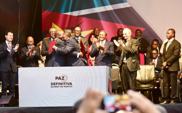 Representatives of the parties to the conflict embrace each other after the signing of the peace agreement.