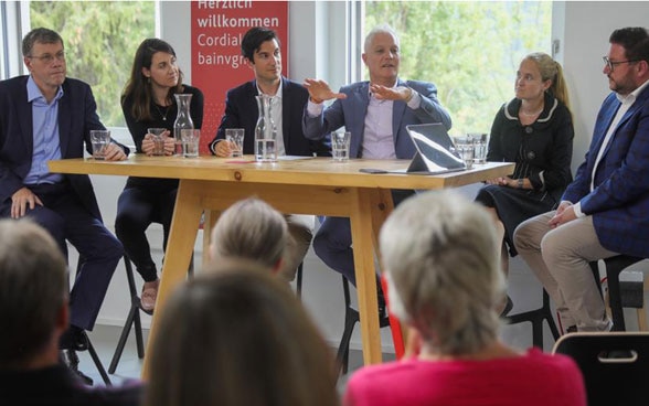 Ambasciatori e ambasciatrici svizzeri siedono attorno ad un tavolo durante la loro visita a Scuol (Grigioni). Discutono la politica estera svizzera e il loro lavoro con il pubblico.