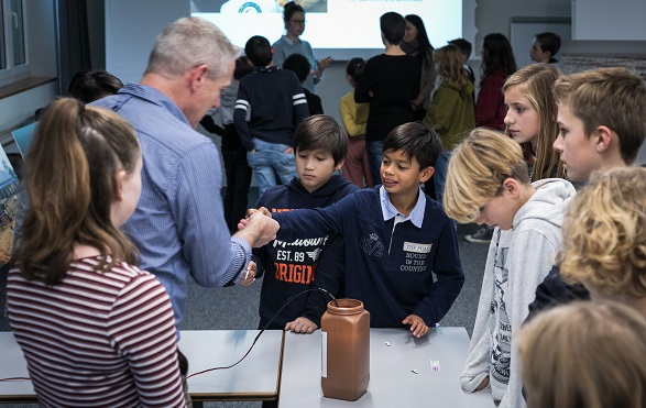 A man shows children how water is purified to make it drinkable.