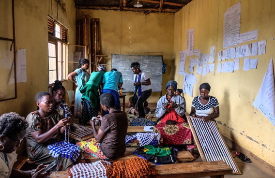 Des femmes réunies dans une salle effectuent des travaux de tissage dans le cadre d’un programme qui vise à la diminution des violences envers les femmes et à l’amélioration de leur statut au Burundi, Rwanda et République Démocratique du Congo.