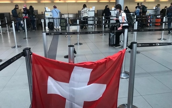 Dans le hall de l'aéroport de Bogota, un drapeau suisse est accroché au comptoir d'enregistrement du vol à destination de la Suisse.