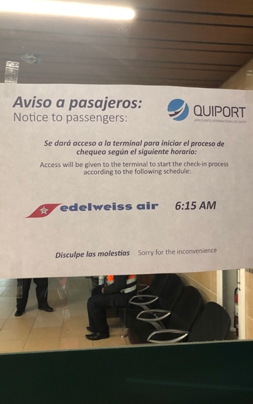 Une affichette sur une porte d’un terminal de l’aéroport de Quito, Equateur, indique aux voyageurs des restrictions d’horaires pour l’accès, suite à l’épidémie de Coronavirus. 