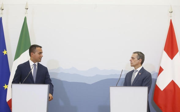 Bundesrat Cassis und der italienische Aussenminister Luigi Di Maio stehen je hinter einem Rednerpult. Im Hintergrund sind die Flaggen der Schweiz, Italiens und der EU zu sehen.