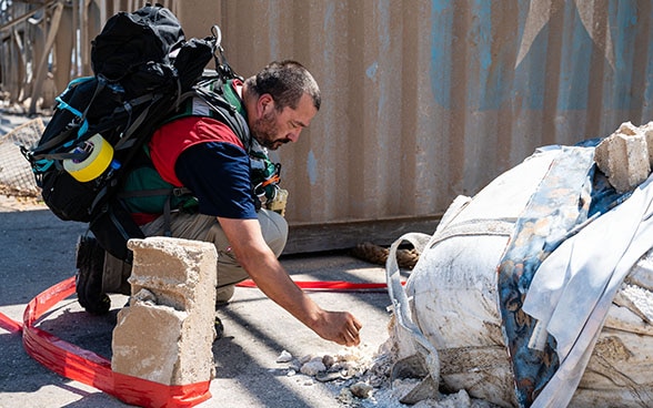 Un expert de l'aide humanitaire suisse prélève des échantillons dans les halls démolis du port de Beyrouth.