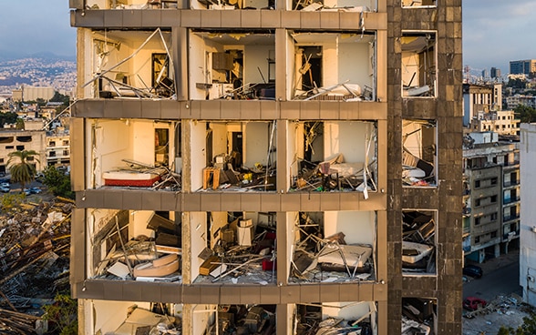 Aerial photograph with a view into a destroyed apartment block, where all windows are missing. 