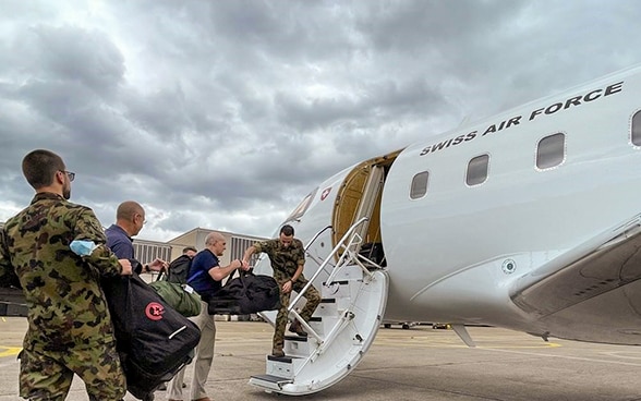  Varie persone stanno caricando i bagagli su un aereo.