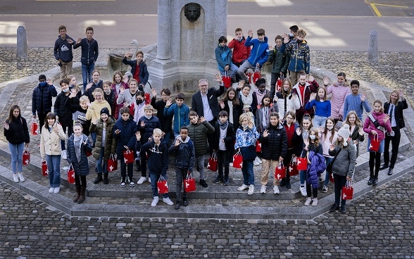 Il segretario generale del DFAE Markus Seiler posa con i 50 bambini davanti al Palazzo federale.