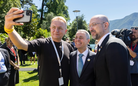 Le maire de Lviv, Andriy Sadovyy, prend un selfie avec le premier ministre ukrainien Denys Shmyal et le président de la Confédération Ignazio Cassis.