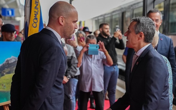 : Le président de la Confédération est accueilli sur le quai de la gare d'Airolo par les autorités et la population.