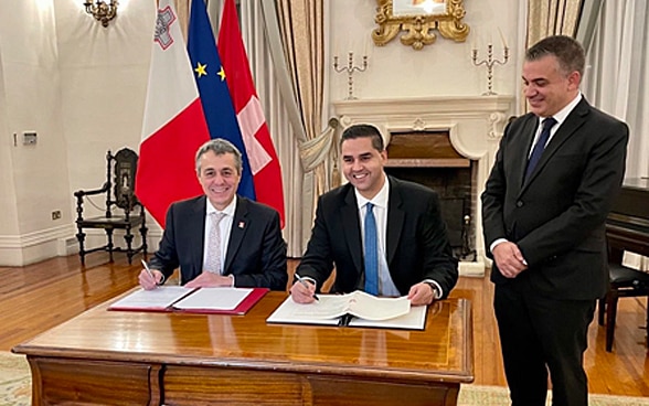 President of the Confederation Ignazio Cassis and Foreign Minister Ian Borg sign an agreement.