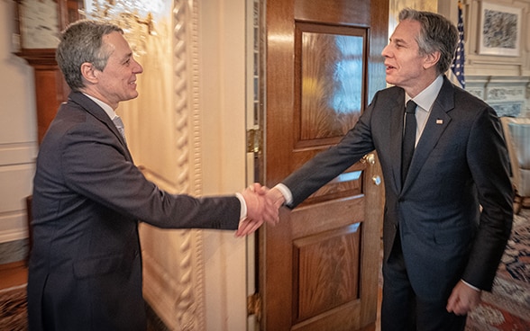 Federal Councillor Cassis and US Secretary of State Blinken approach each other to shake hands.