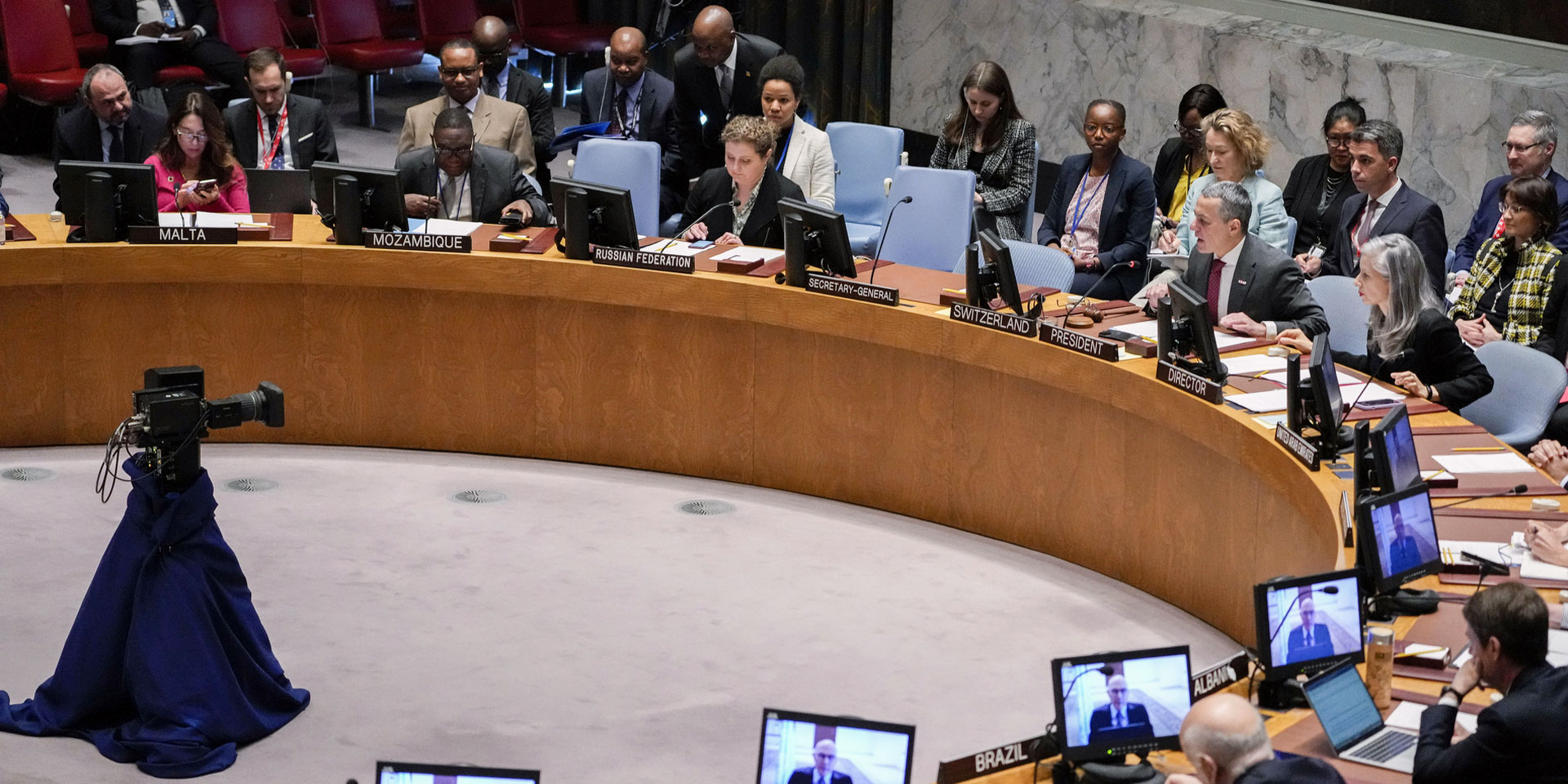 Des hommes et des femmes sont assis à la table en fer à cheval du Conseil de sécurité de l'ONU et écoutent les explications du conseiller fédéral Ignazio Cassis.
