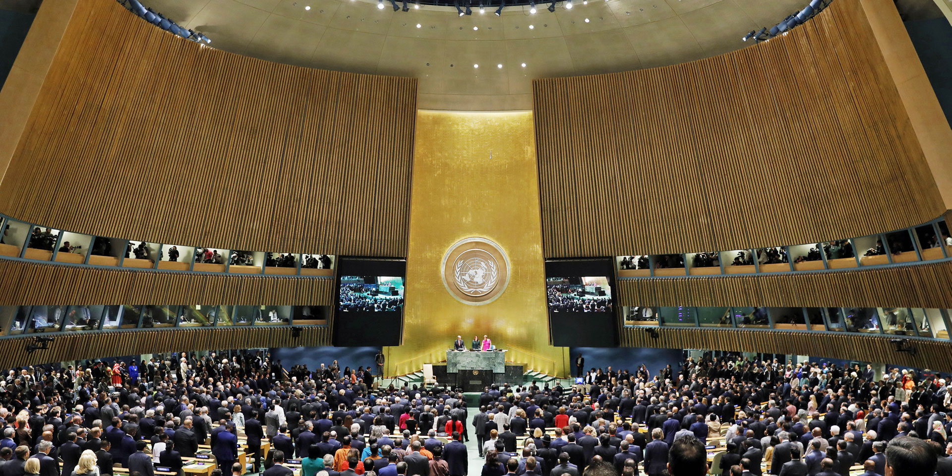 Image of the UN General Assembly hall with a large number of people inside.