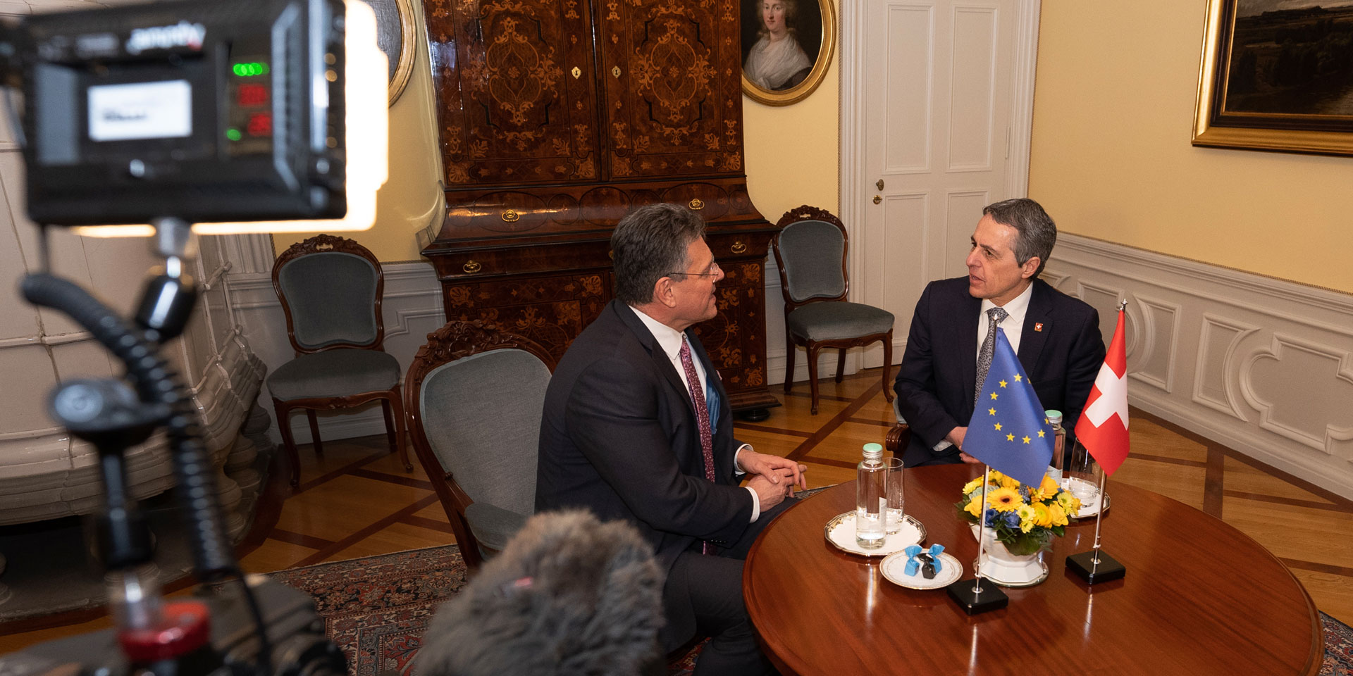 Ignazio Cassis e Maroš Šefčovič sono seduti a un tavolo. Sono esposte le bandiere della Svizzera e dell'Europa.