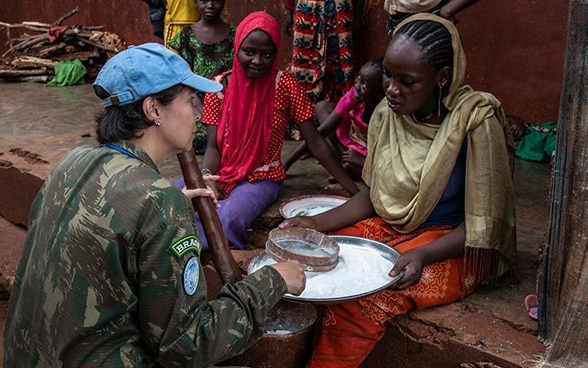 A female commander with MINUSCA talks to a civilian in a village in the Central African Republic.