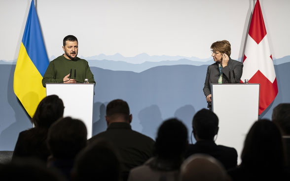 Bundespräsidentin Viola Amherd steht rechts von Präsident Wolodymyr Selenskyj an einem Stehpult.