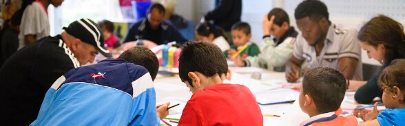 De nombreuses personnes sont assis à une table pour lire ou écrire