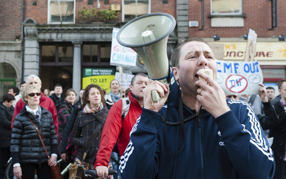 Un uomo con un megafono guida una manifestazione nel centro di Dublino il 12 novembre 2011.