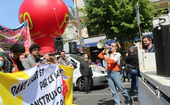 Eine Frau mit einem Megafon nimmt an einer Demonstration teil. 