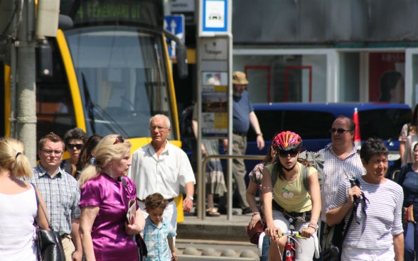 Foule avec tram au fond