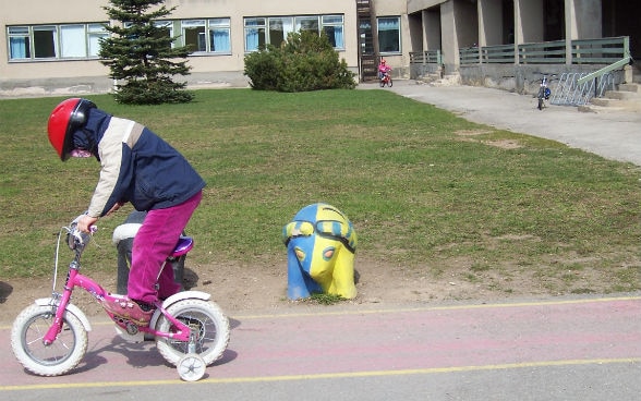 bambino in bicicletta davanti alla scuola di Rakvere