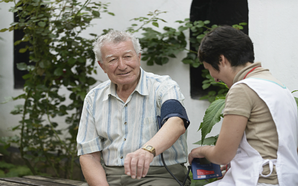 A young carer looking after an elderly patient in a nursing home.