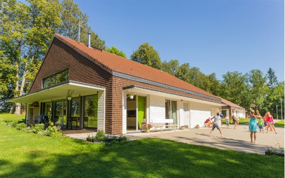 Kinder spielen im Garten vor einem Haus