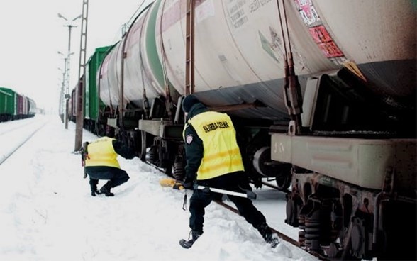 Two border guards check a train.