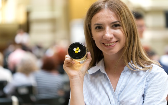 A woman with a jar of honey