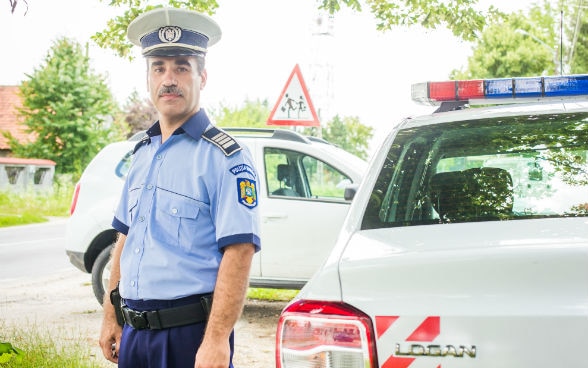 Un policier debout à côté de la voiture 