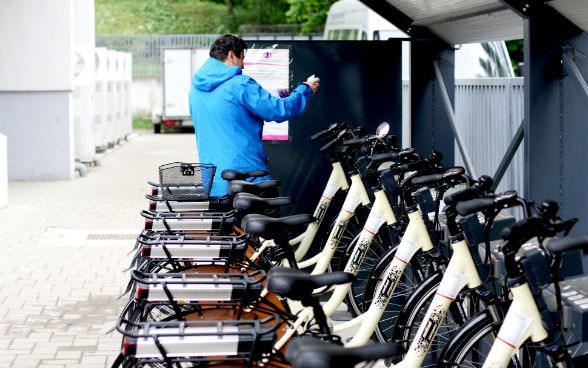 Un homme emprunte un vélo électrique.