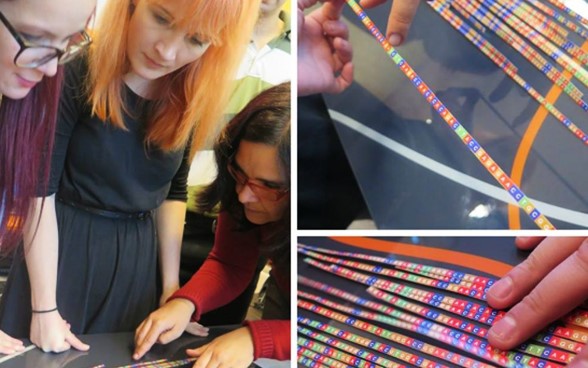 Employees analyse printed DNA sequence data.
